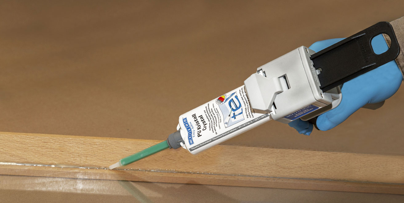 Der Klebstoff Weicon PU Kristall wird auf eine schmale Holzlatte gegeben