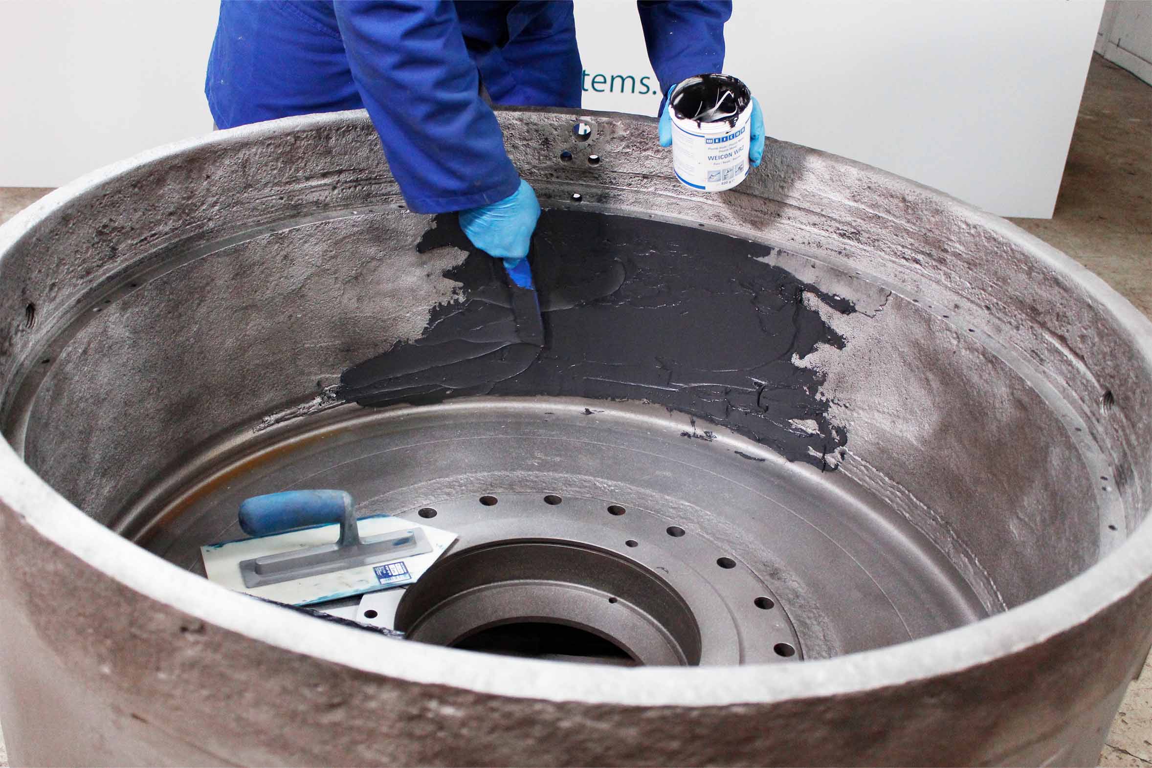 Verschlissene Pelletpresse wird mit Reparaturmasse bestrichen