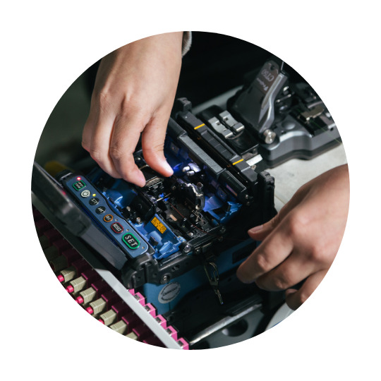 Zwei Hände arbeiten an einem Elektronikteil