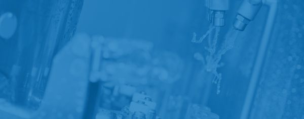 Vue détaillée de têtes de pulvérisation et de composants mécaniques sur une ligne de production automatisée.