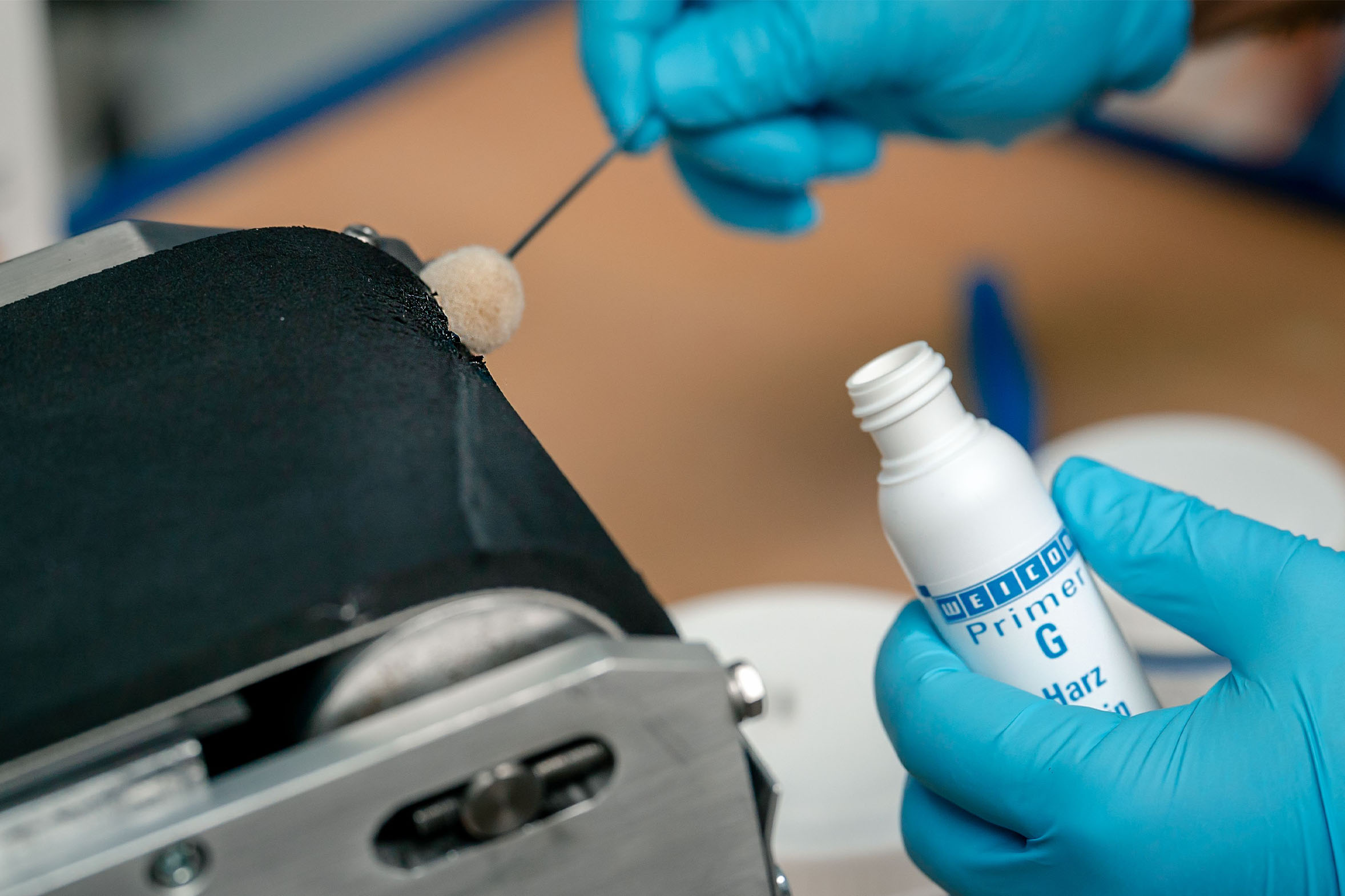 Weicon Primer G wird mit Wollwischer auf Förderband getragen