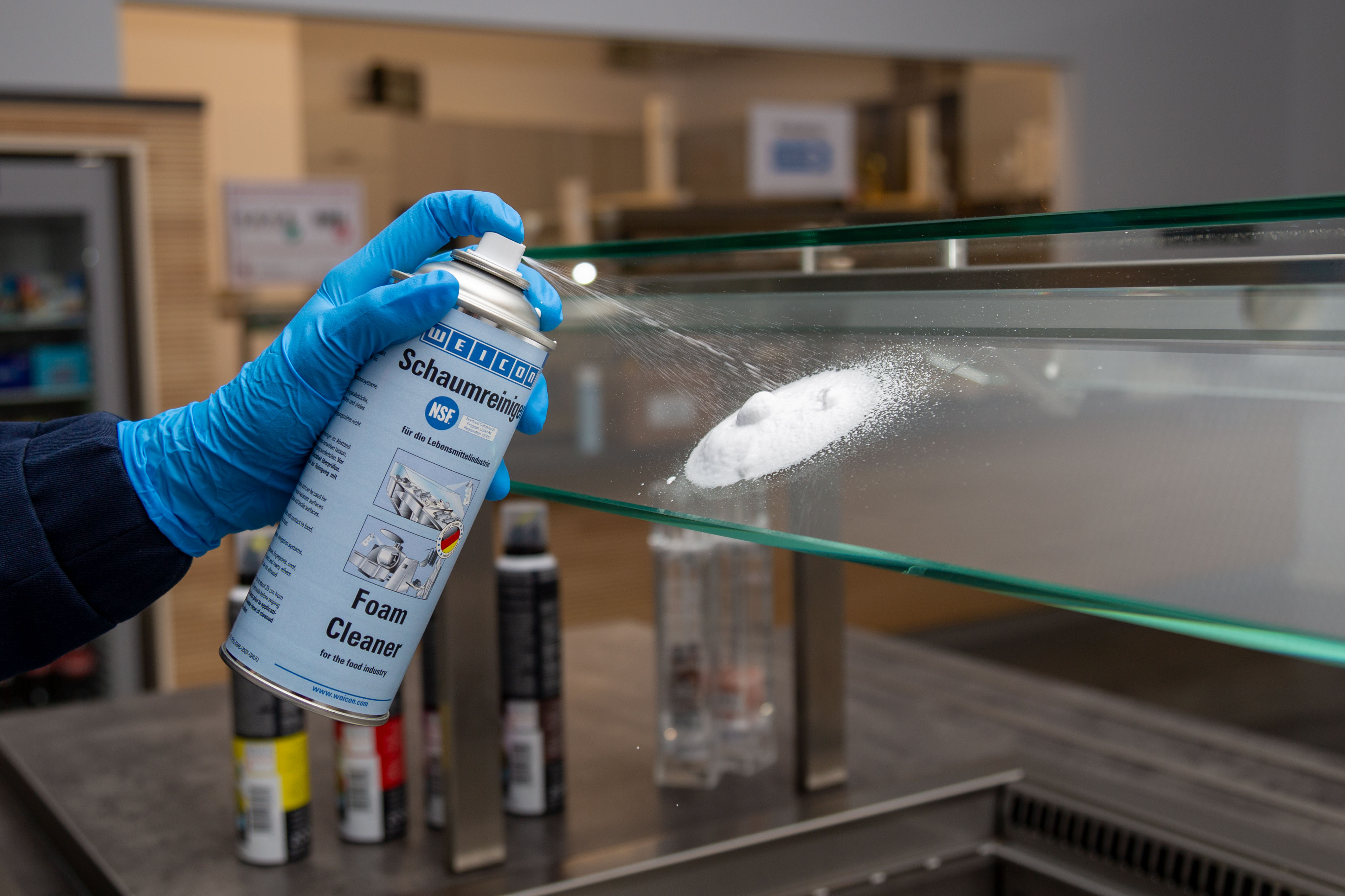 Landingpage_Einsatzgebiete_Lebensmittel_Schaumreiniger_Bild3 Weicon Schaumreiniger wird auf eine Glasscheibe in einer Küche gesprüht