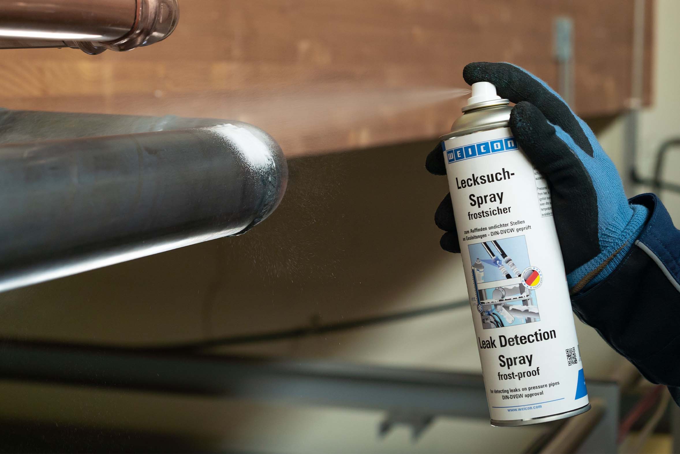 Weicon Lecksuch-Spray frostsicher wird auf Rohr gesprüht