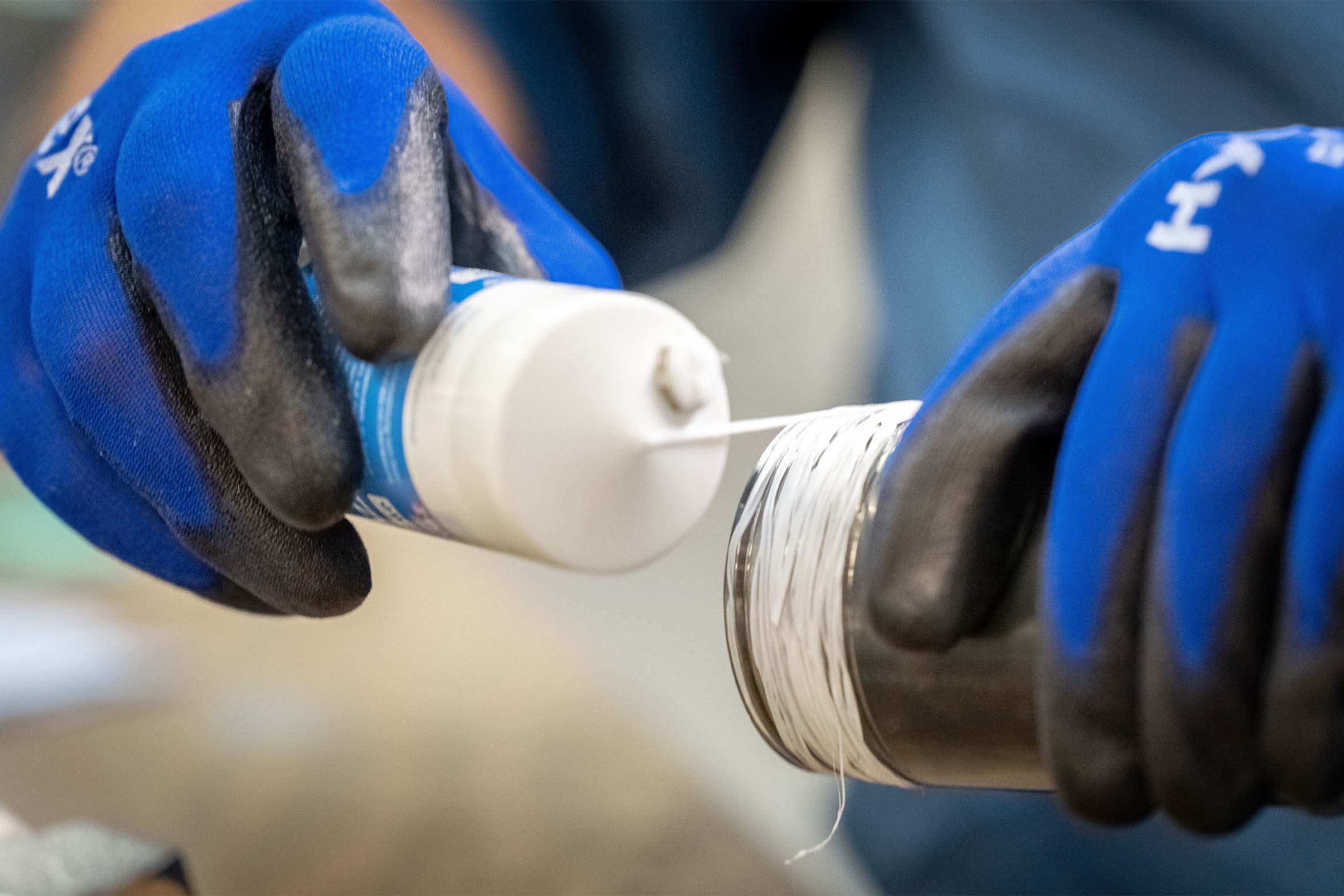 Gewindedichtfaden wird um dickes Gewinde gewickelt