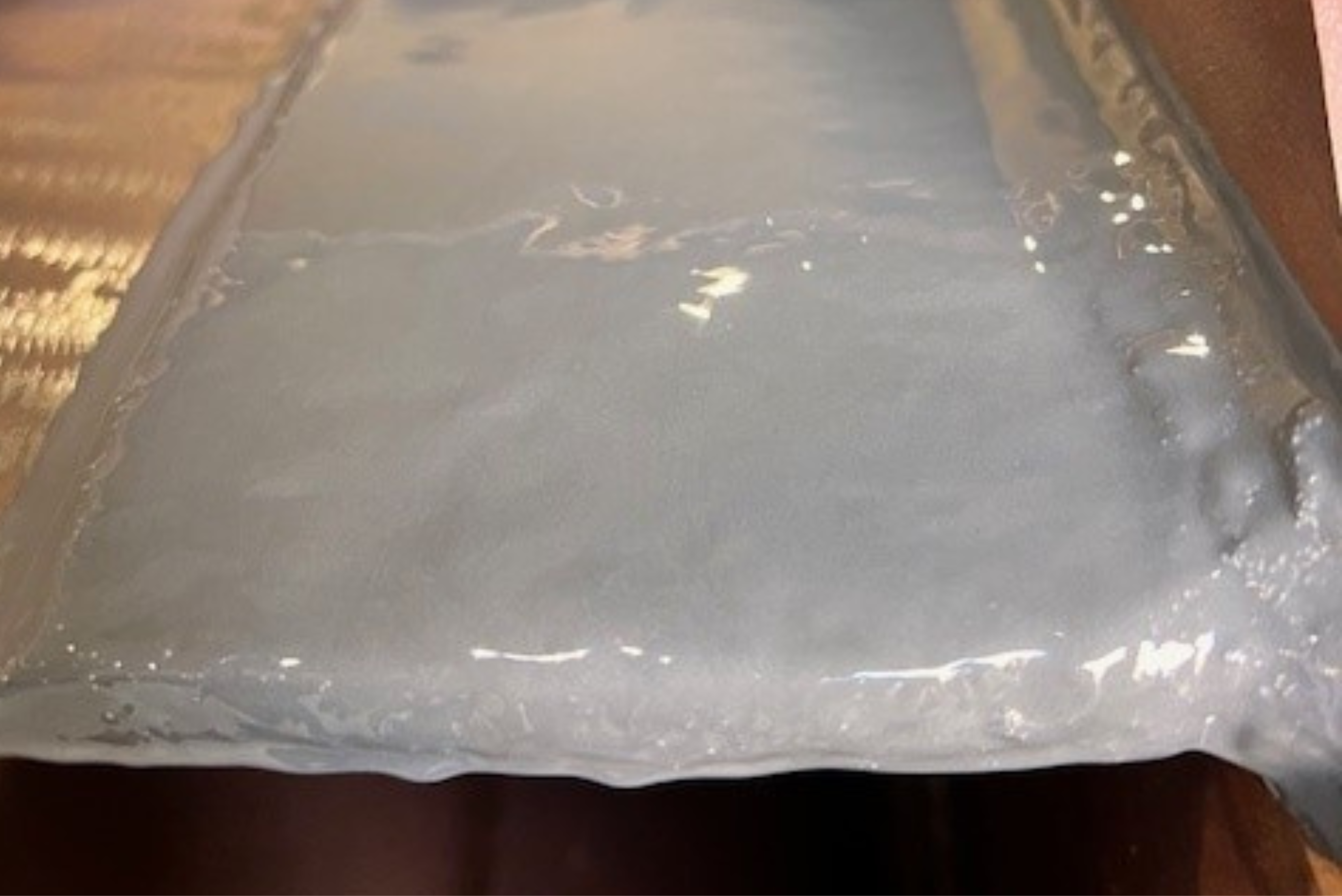 Una superficie metallica rivestita uniformemente con uno strato protettivo di resina epossidica o silicone grigio lucido.