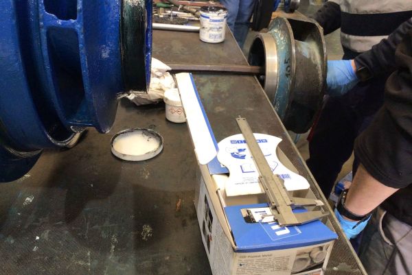 Préparation et assemblage de composants de pompe industrielle avec des produits WEICON et des outils de mesure sur un établi d'atelier.